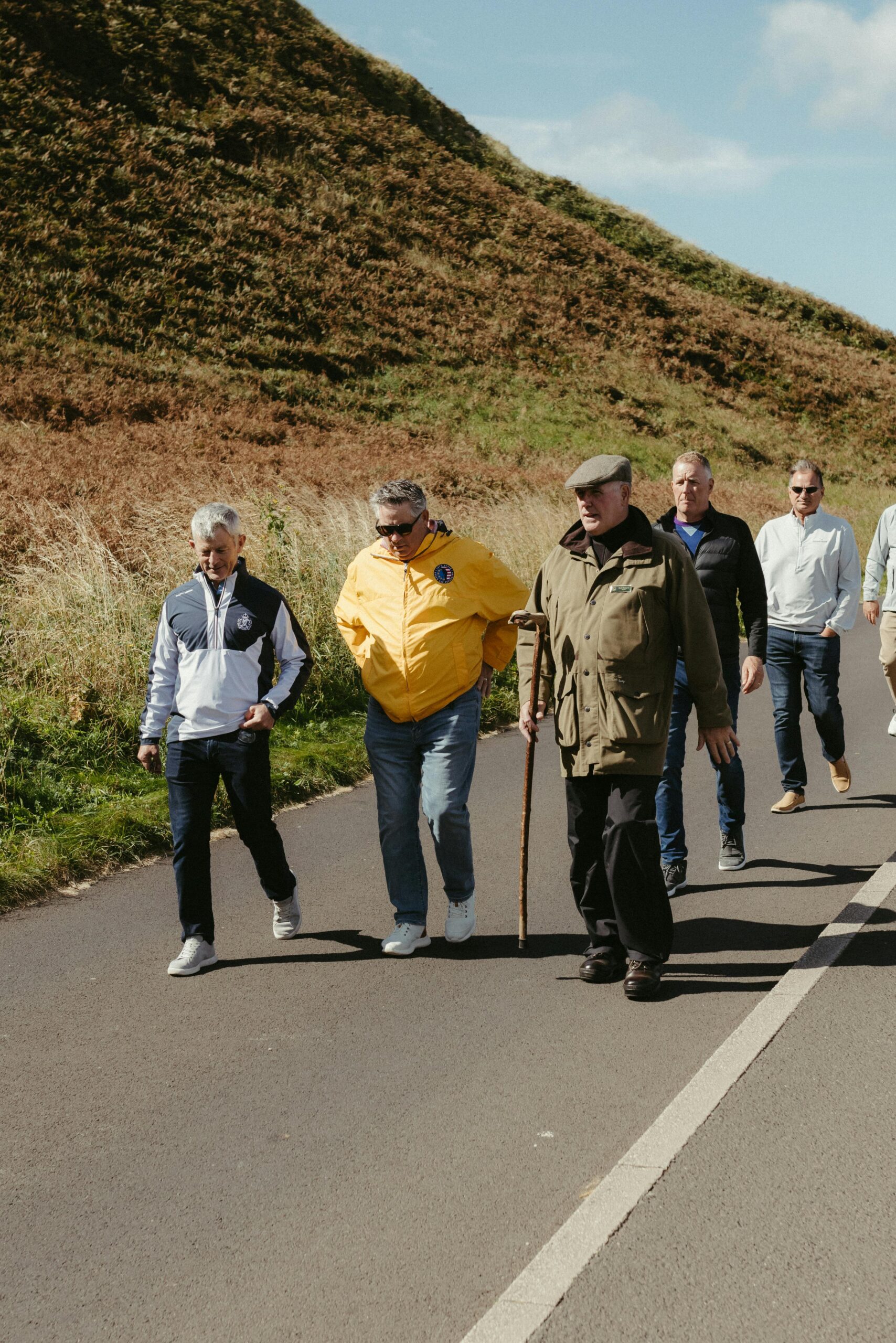 A group of adults walking together on a sunny day in Northern Ireland, showcasing friendship and outdoor activity.